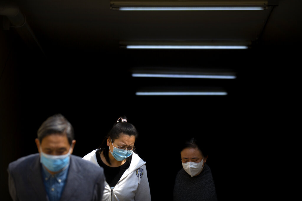People wear face masks as they exit a subway station in Beijing, Tuesday, April 7, 2020. China on Tuesday reported no new deaths from the coronarivus over the past 24 hours and just 32 new cases, all from people who returned from overseas