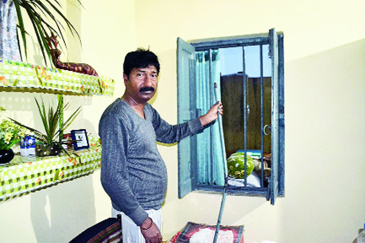 Subir Kumar Sutradhar shows a broken window at his burgled house in Agrico, Jamshedpur, on Thursday. 