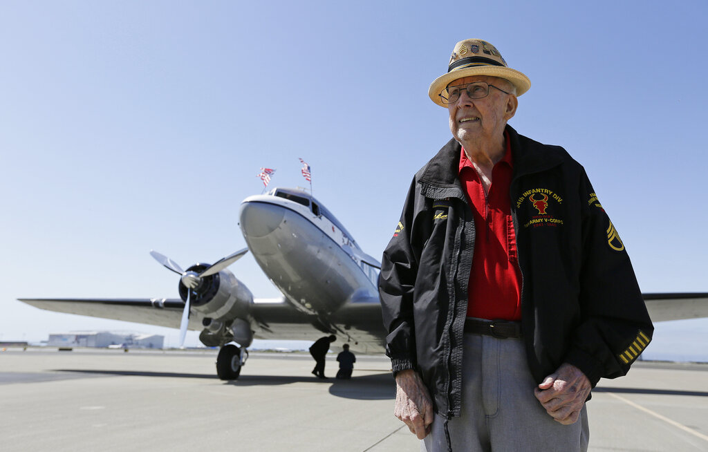 In this photo taken April 29, 2019, D-Day veteran Jake Larson poses before going for a ride in the The Spirit of Benovia World War II-era aircraft in Oakland, California. Both Larson and the former C-53 Skytrooper transport plane plan to be in Normandy and take part in events for the 75th anniversary of D-Day. The plane takes its name after a winery in Sonoma County.