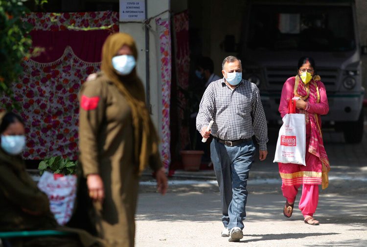 Indians wearing protective face masks as a precaution against COVID-19