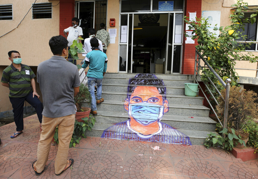 A mural is seen painted on the steps of a police station as stranded migrant workers wait to register for a special train to their native destination during extended lockdown to curb the spread of coronavirus, in Bangalore, Monday, May 18, 2020.