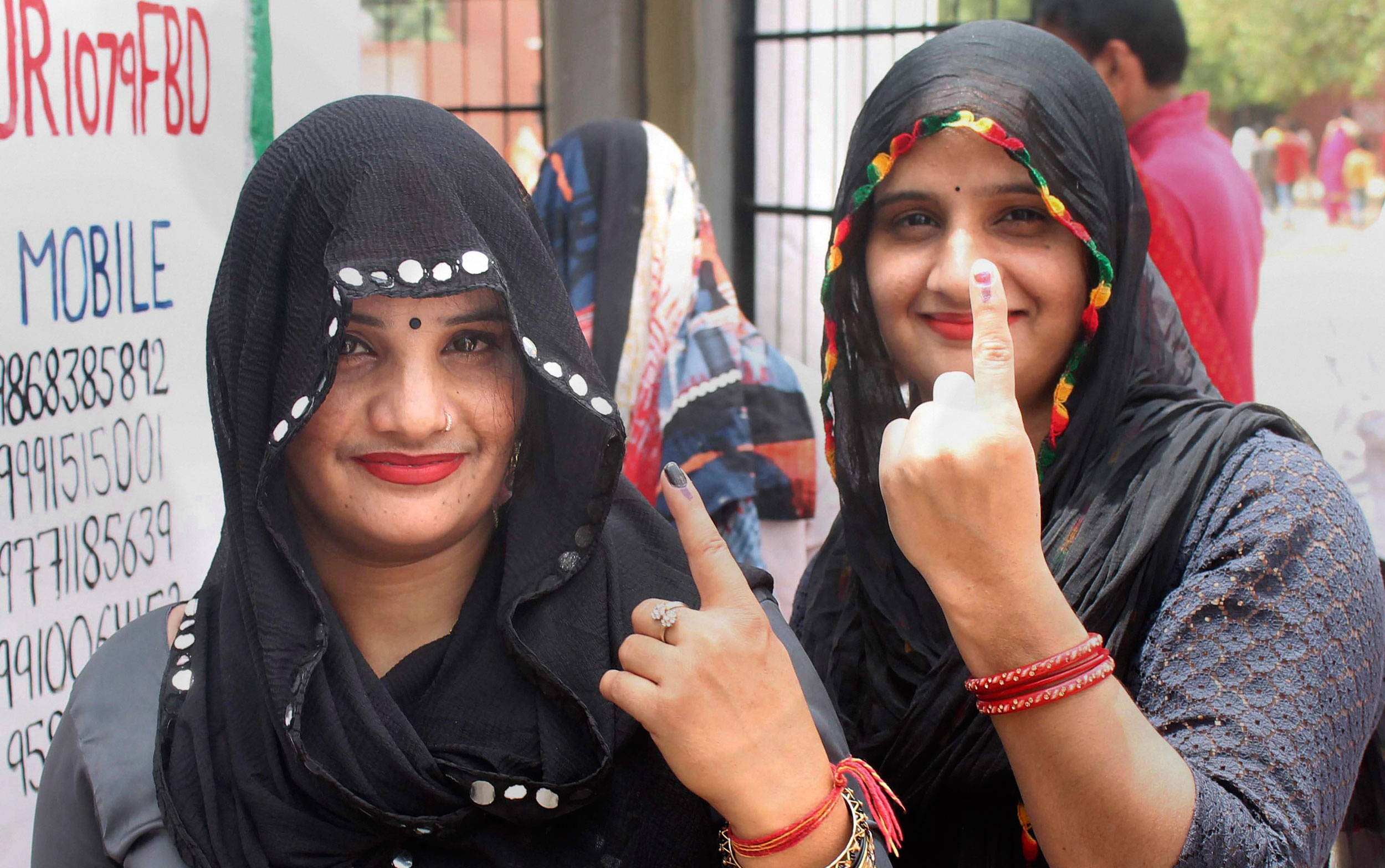 Voters show their fingers marked with indelible ink outside a polling booth during the sixth phase of Lok Sabha polls, in Faridabad, on May 12, 2019.