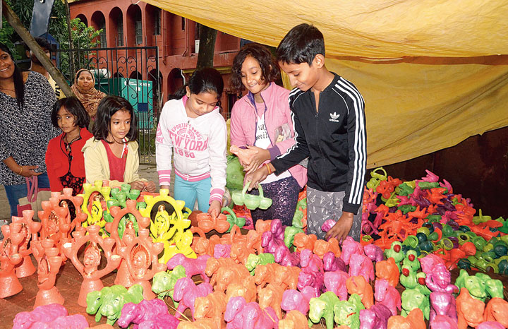 Kids buy earthen diyas at Doranda Bazaar in Ranchi on Saturday