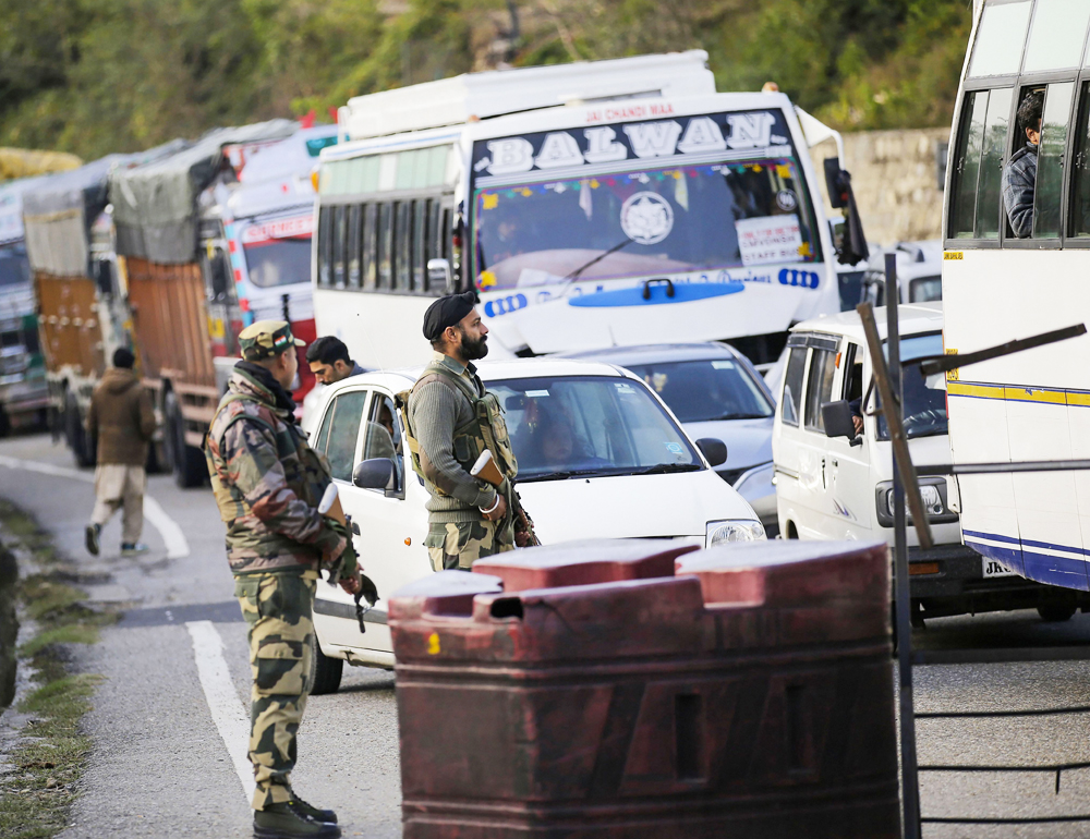 Security personnel stand guard on the Jammu and Kashmir National Highway after it was closed following heavy rains, in Jammu, Friday, November 29, 2019.