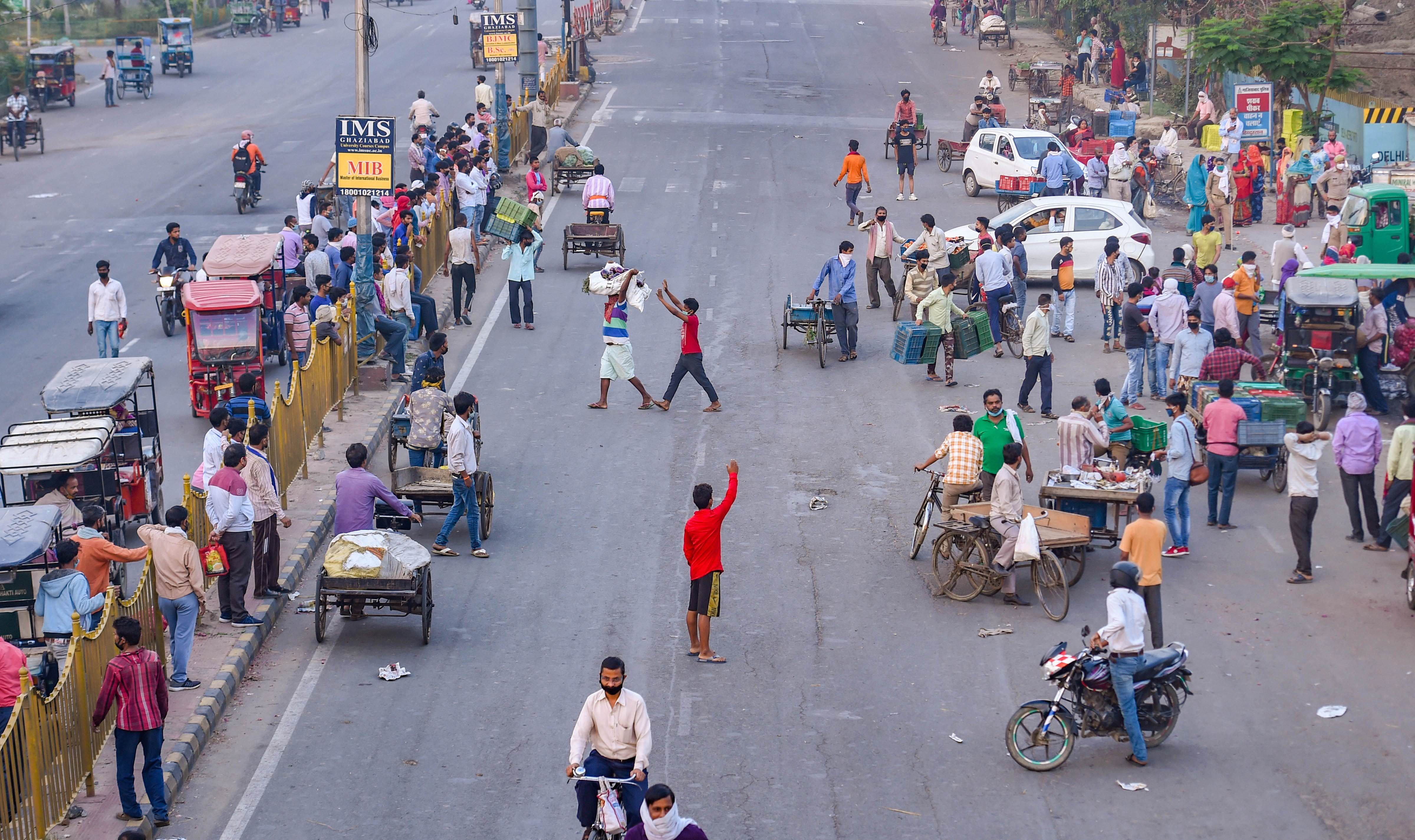 People are seen at a vegetable market early morning where the entry of outsiders is restricted during a nationwide lockdown imposed in the wake of coronavirus pandemic, in Ghaziabad, Monday, April 20, 2020