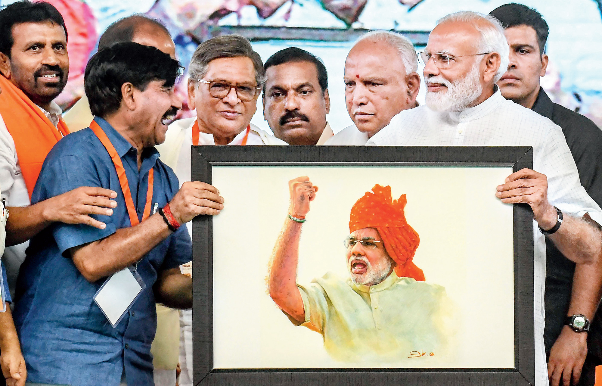 How’s the joke, Sir? A guffawing admirer and a more restrained Prime Minister hold a telling portrait during an election rally in Mysore on Tuesday. 