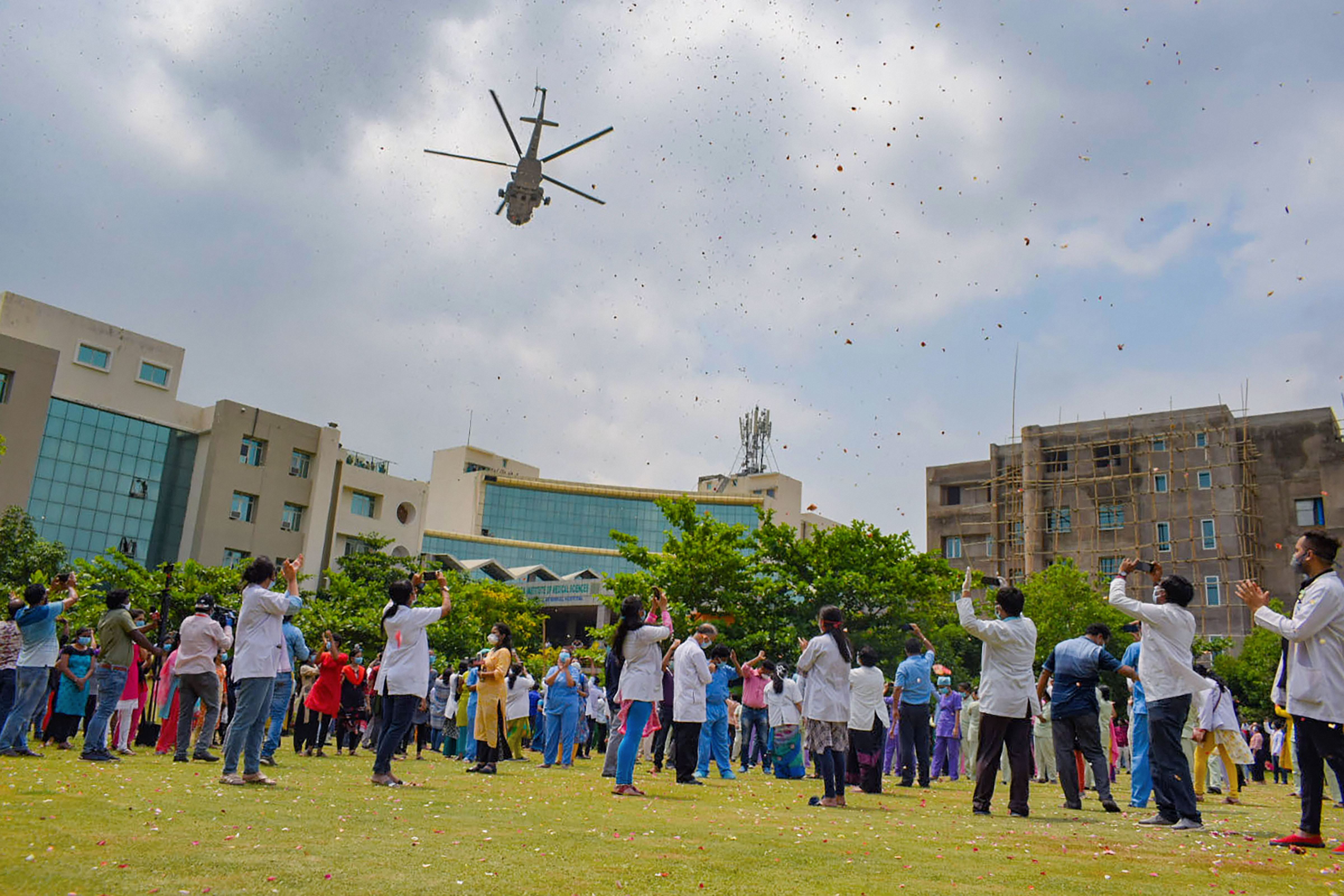 An Indian Air Force chopper showers flowers on medical professional at Kalinga Institute of Medical Science to express gratitude towards them in fighting Covid-19, in Bhubaneswar, Sunday, May 3, 2020.