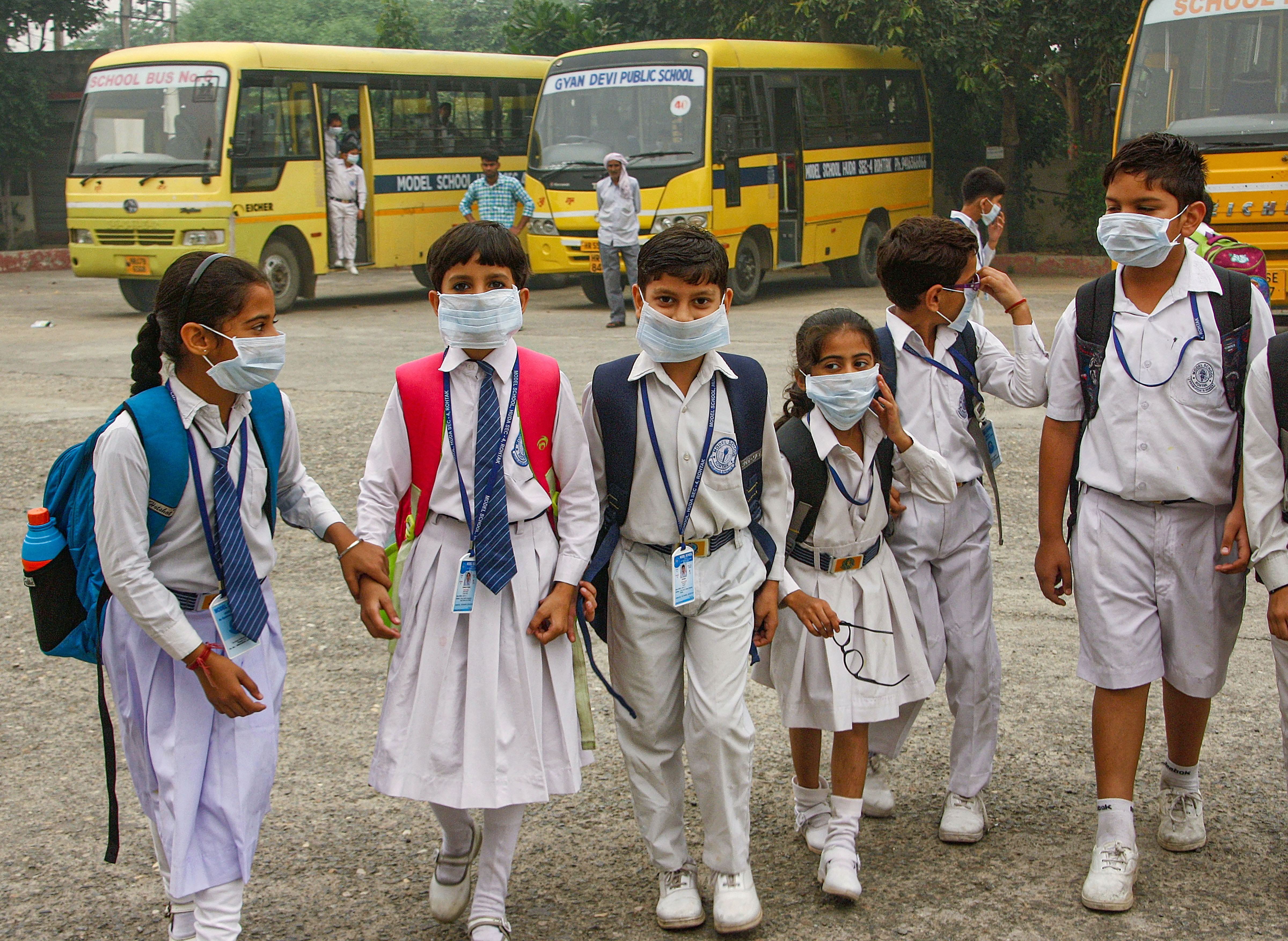 Students wearing mask walk amid an atmoshphere shrouded in smog in Rohtak, Saturday, November 2, 2019.