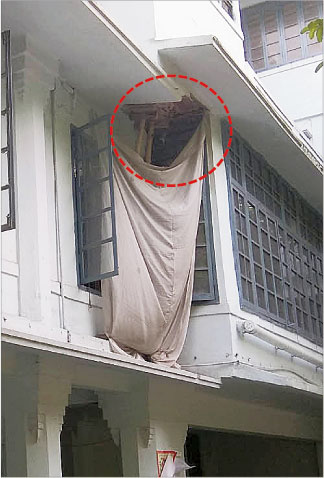 A portion of the building with chunks of concrete coming off