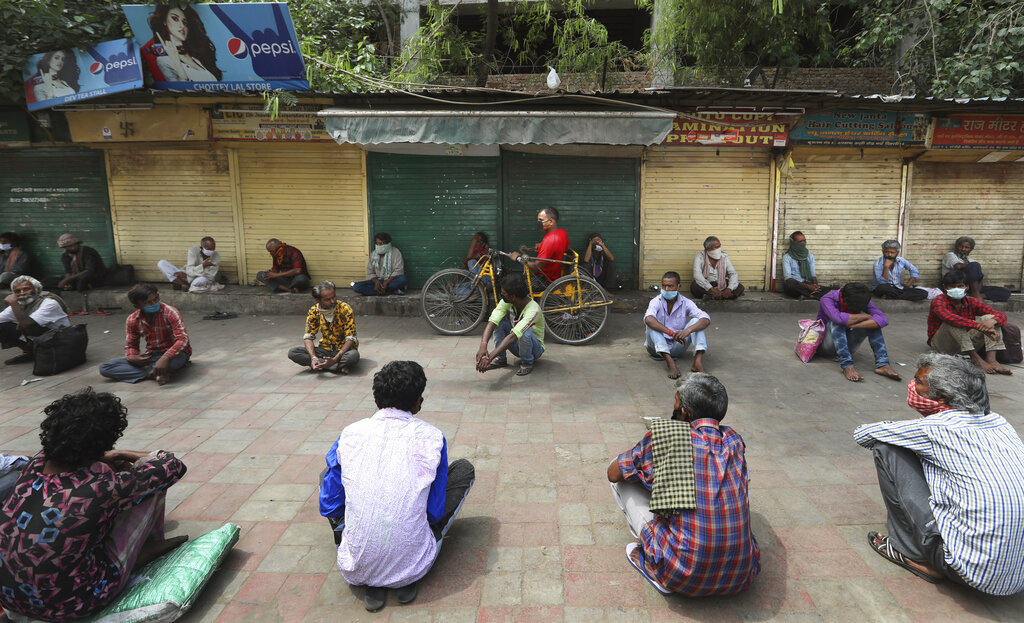 Homeless people wait for free distribution of food during extended lockdown in New Delhi, Monday, May 4, 2020.