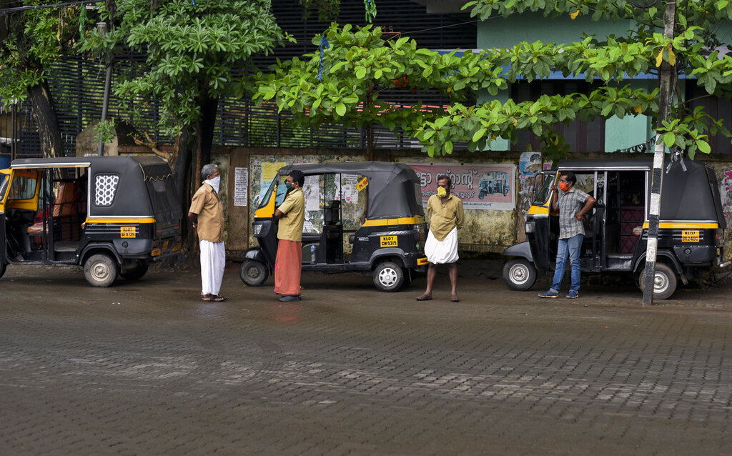 Auto rickshaw drivers wearing masks wait for customers on the day their services resumed in Kochi, Tuesday, May 19, 2020. 