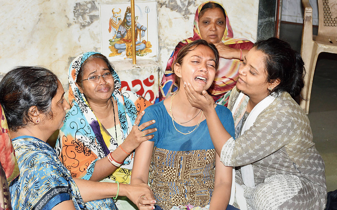 Family members of one of the students who died in the fire mourns in Surat. 