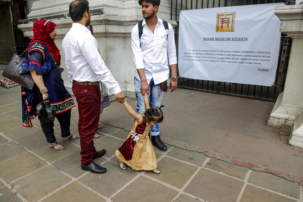 Tourists from Bangladesh stand in front of the Indian Museum which is declared closed till March 31as a precautionary measure against COVID-19 in Kolkata, on Sunday, March 15, 2020. For most people, the new coronavirus causes only mild or moderate symptoms. For some, it can cause more severe illness, especially in older adults and people with existing health problems.