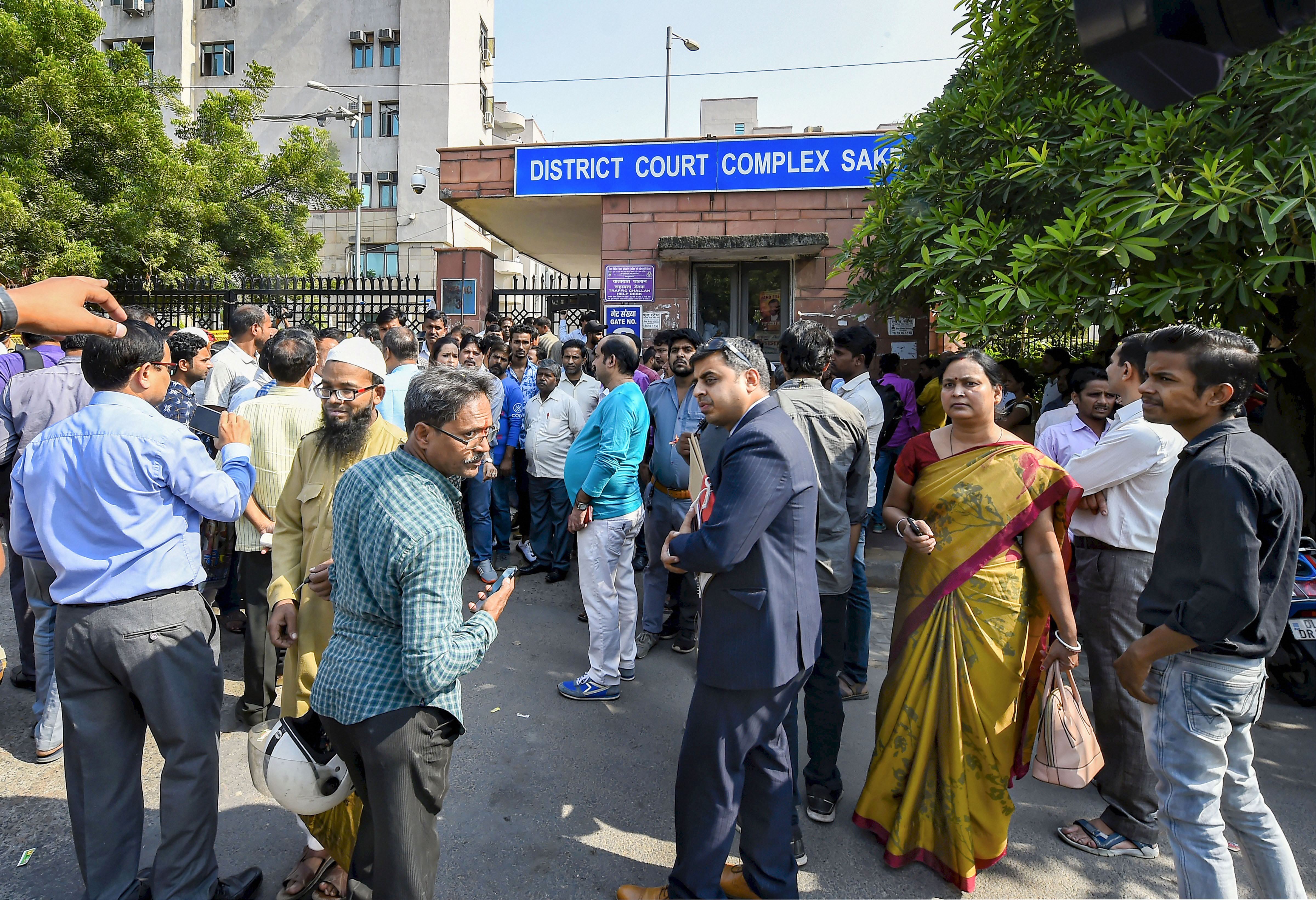 People wait outside Saket court during lawyers protest inside the court premises over last week's incident of clashes between lawyers and the police at Tis Hazari Court complex, in New Delhi, Wednesday, November 6, 2019.