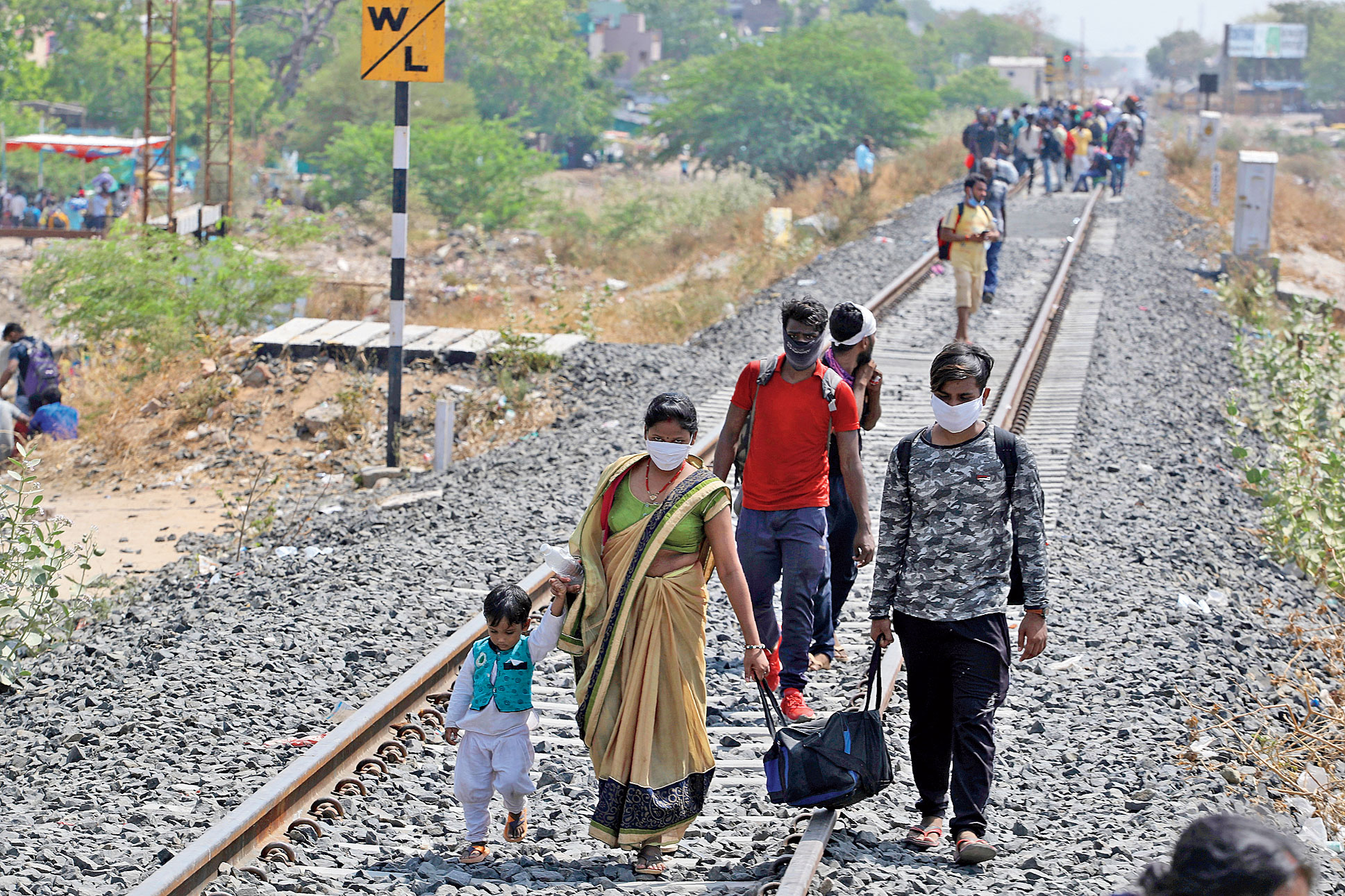 Migrant workers walk on rail tracks towards a railway station in Ahmedabad on Monday but were turned away as no train was scheduled to their state that day.