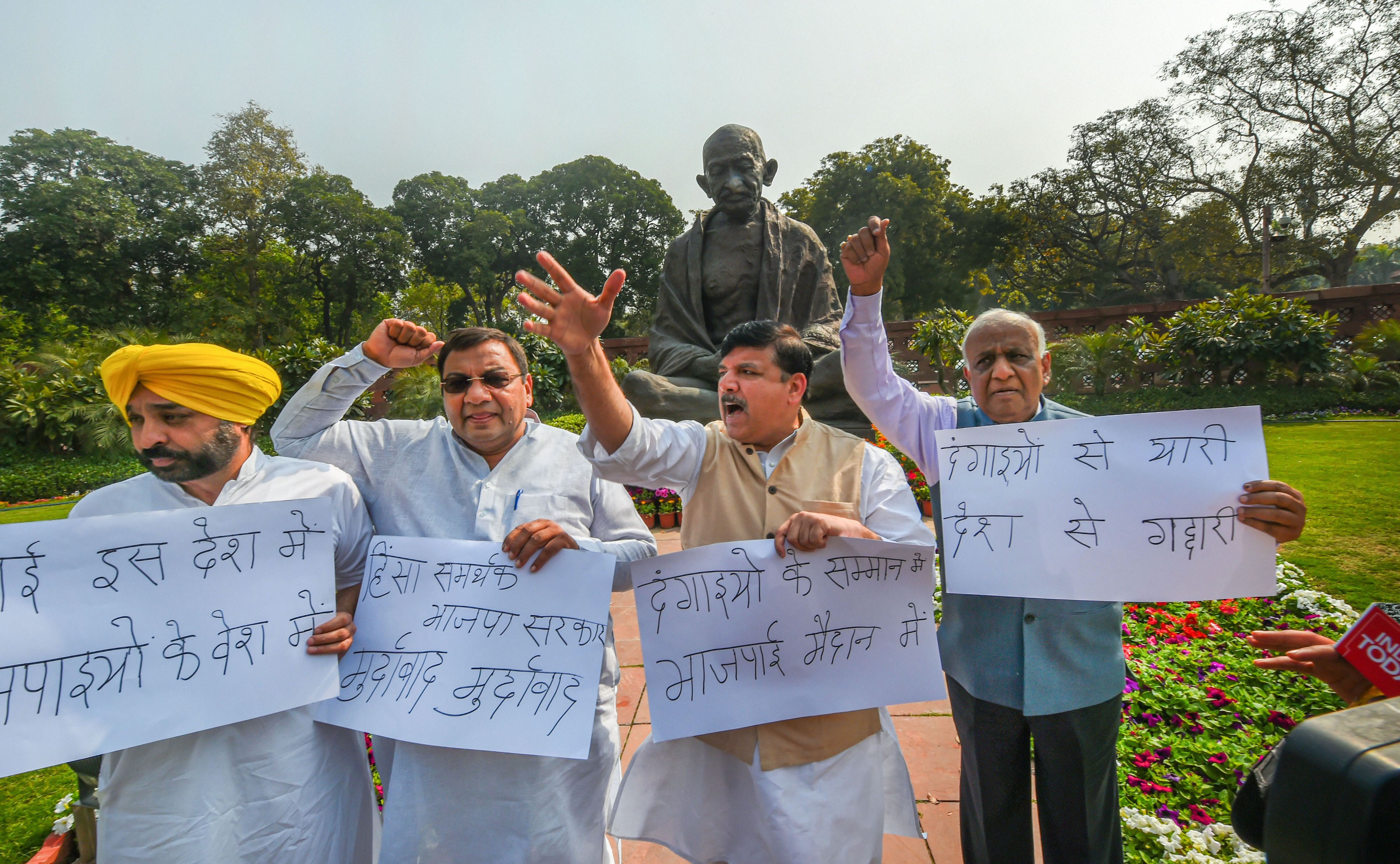 Aam Aadmi Party MPs Sanjay Singh, Bhagwant Mann, N. D. Gupta and Sushil Gupta raise slogans during a protest over Delhi violence, at Parliament during the ongoing Budget Session, in New Delhi, Monday, March 2, 2020