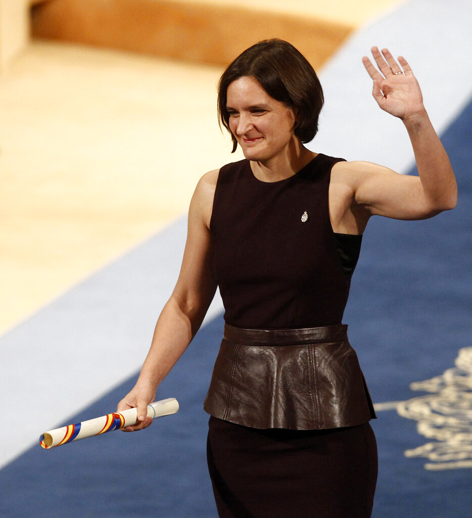 In this Friday October 23, 2015, file photo, Esther Duflo of France waves after receiving the Princess of Asturias award for Social Sciences from Spain's King Felipe VI at a ceremony in Oviedo, northern Spain.