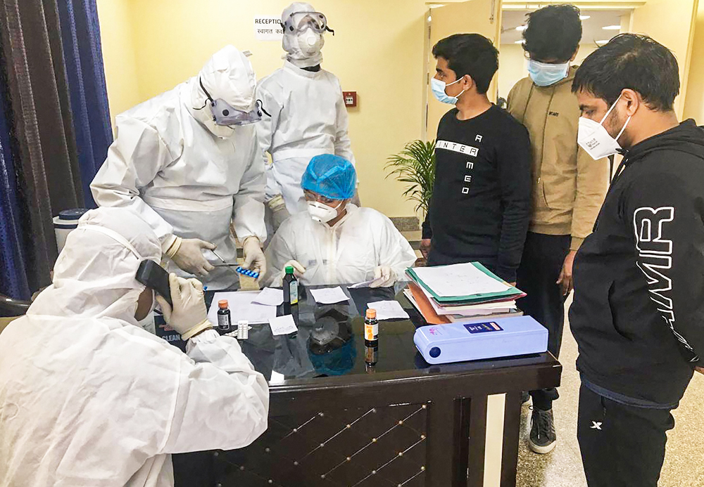 In this handout photo provided by Indo-Tibetan Border Police (ITBP), Indian nationals who were airlifted from coronavirus-hit Wuhan city of China's Hubei province, undergo tests inside a quarantine facility set by up ITBP, at Chhawla area of New Delhi, Monday, February 3, 2020. 