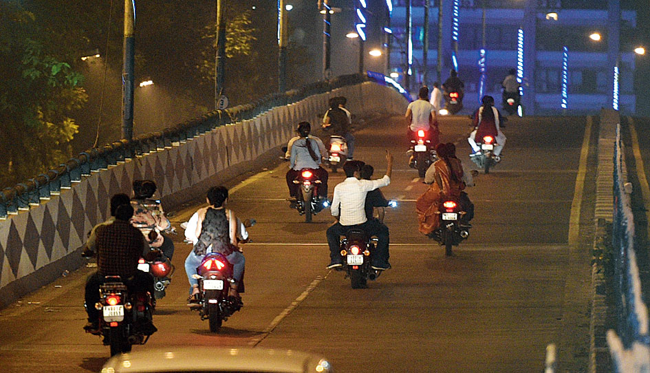 Risky motorcycle riding, without helmet, on Park Street flyover in Calcutta.