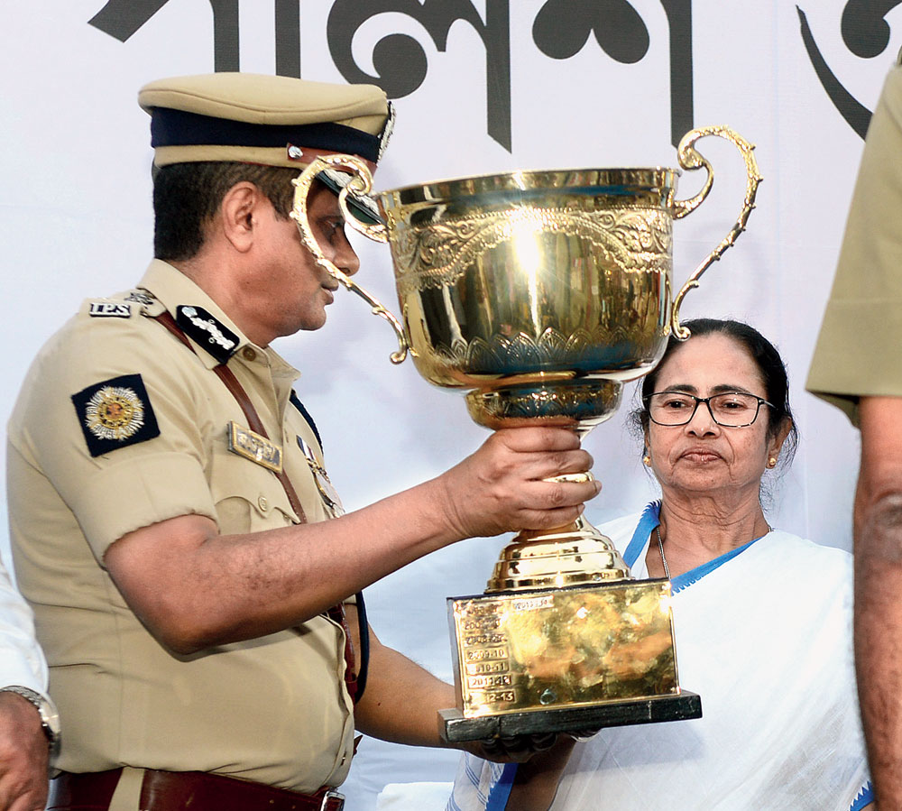 Calcutta police chief Rajeev Kumar passes on a trophy to chief minister Mamata Banerjee at the police investiture ceremony in Calcutta on Monday. 