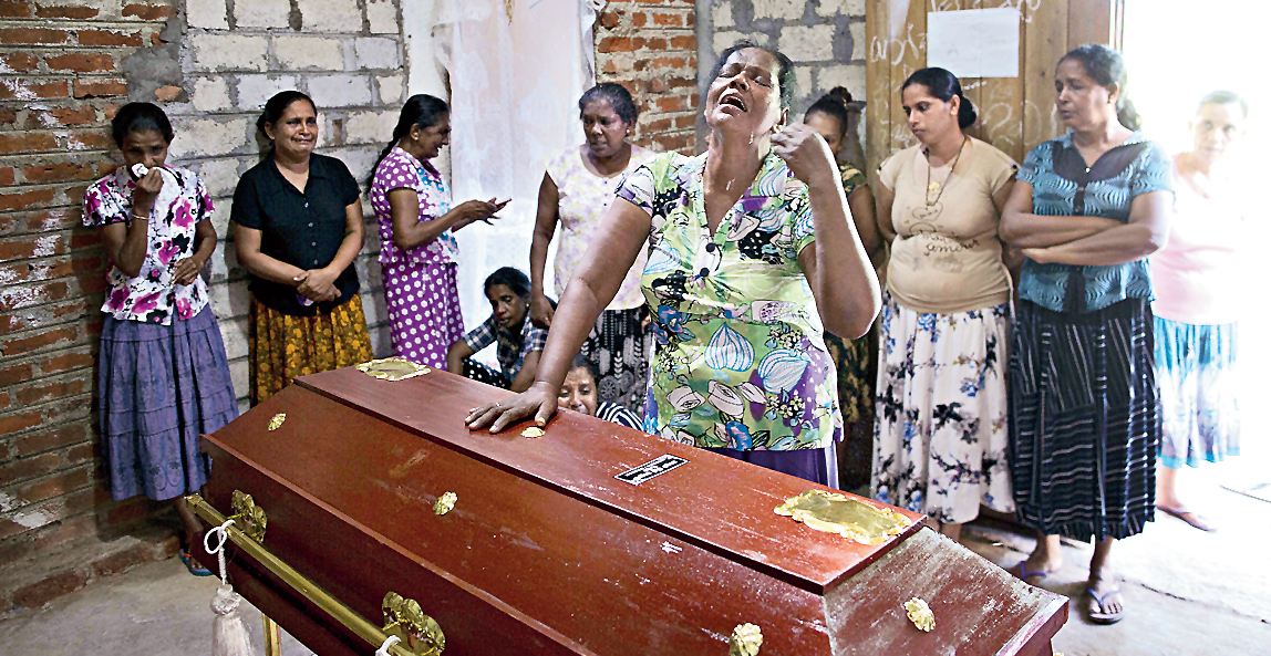 Lalitha (centre) cries near the coffin which contains the remains of her 12-year old niece Sneha Savindi who was killed in the Easter Sunday bombing in Negombo, Sri Lanka. 
