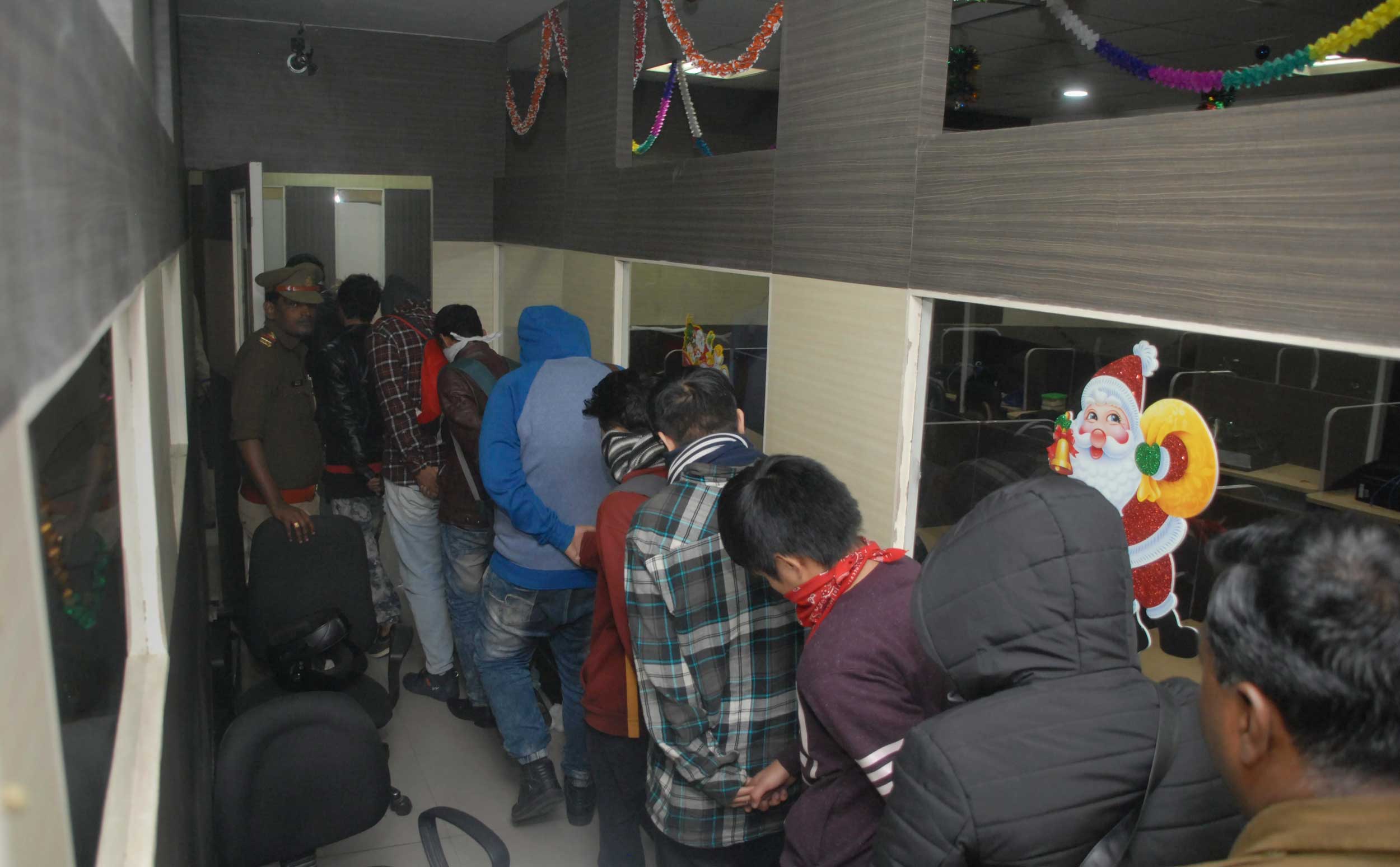 Employees of a fake call centre, allegedly duping US citizens, during a police raid, in Noida, on Friday. 