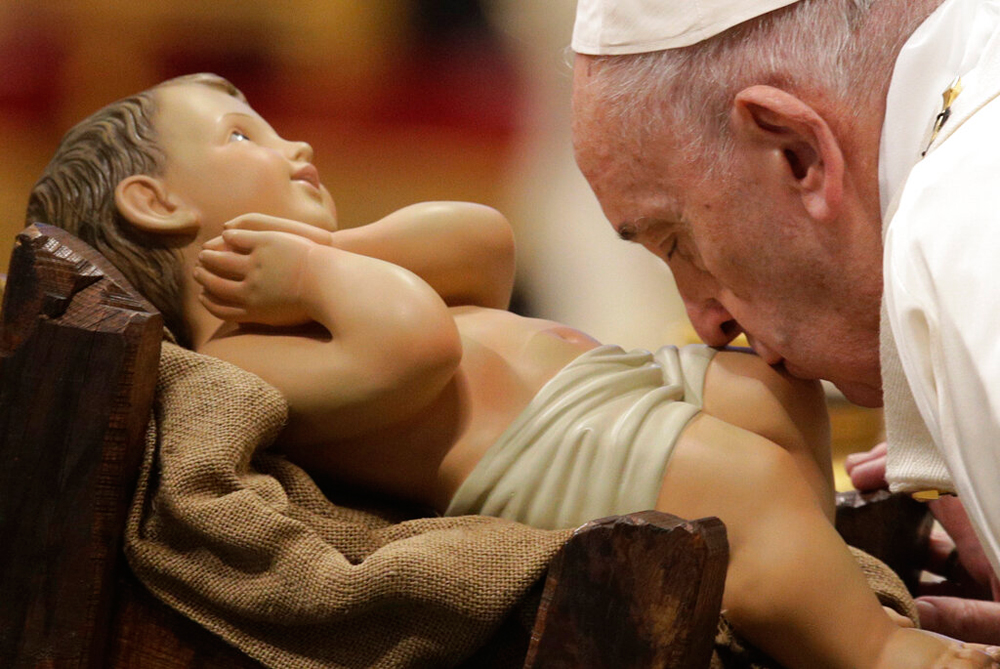 Pope Francis kisses a statue of Baby Jesus in St Peter's Basilica at the Vatican on January 1