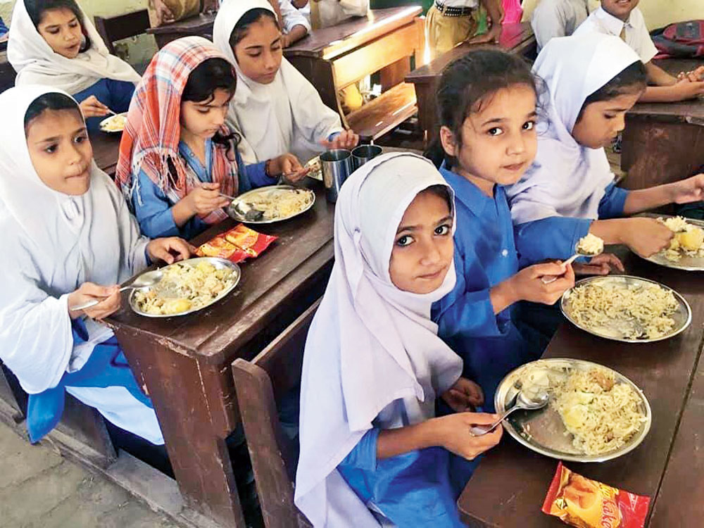 School children in Pakistan’s Qayyumabad eating meals made possible by the organisation