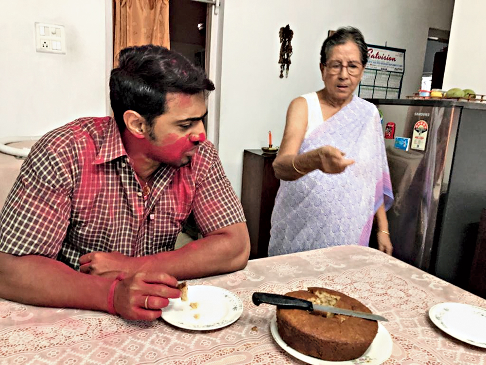 Dev tastes a slice of a cake baked by Sabita Ganguly in course of the shoot at her house