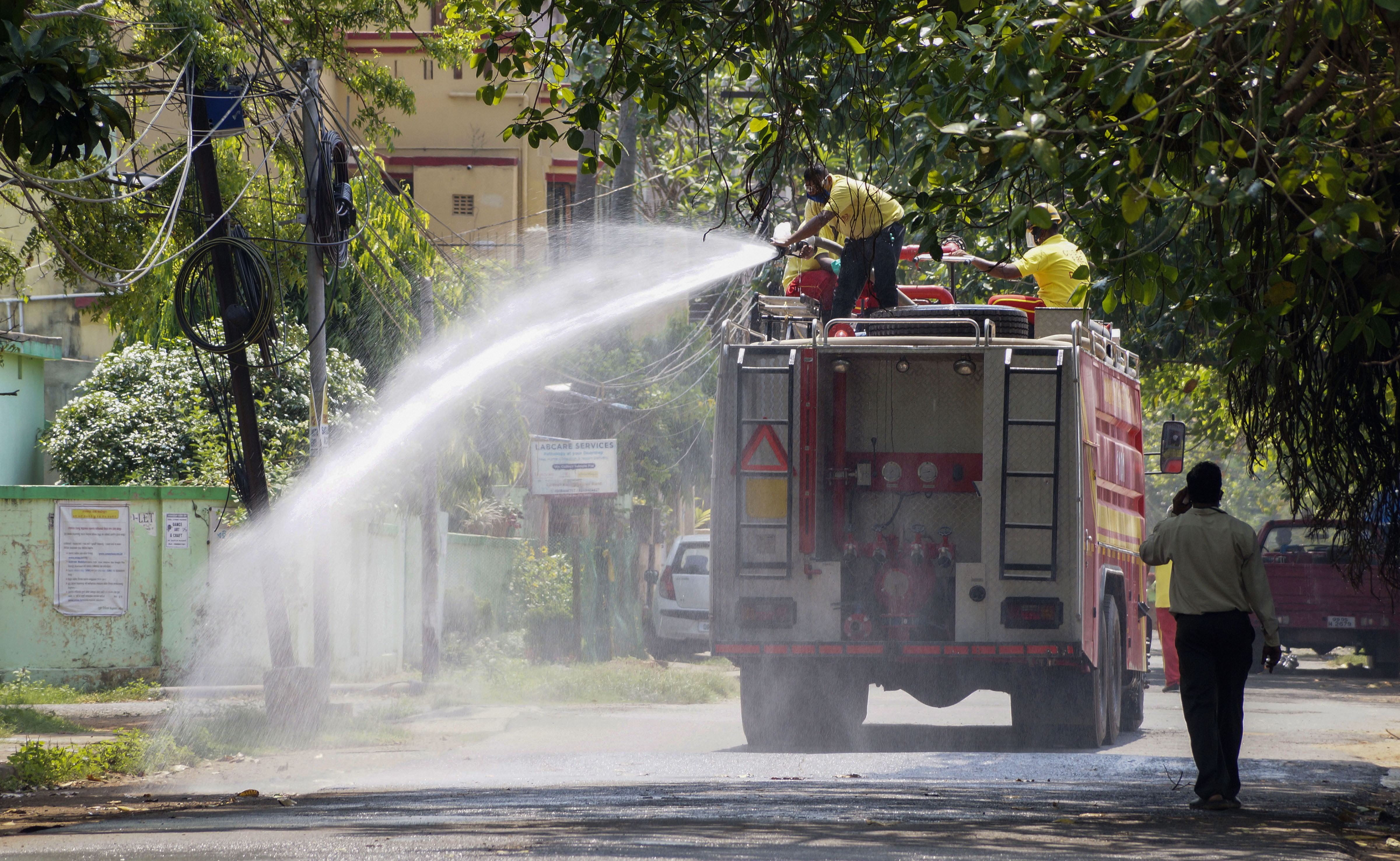 Firefighters spray disinfectant on a street during a nationwide lockdown in the wake of the coronavirus pandemic, at Surya Nagar in Bhubaneswar, Friday, April 3, 2020