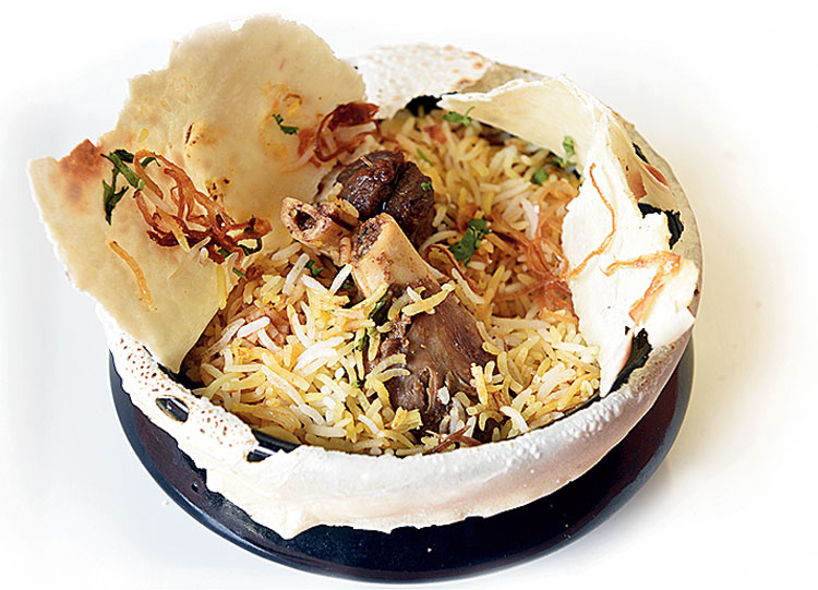 Paya Parda Biryani: This aromatic biryani made with basmati rice, lamb nalli with coriander and fried onion as garnish, has a thin layer of parda (made with white flour), making sure that the flavours remain intact. Served with a raita, the biryani is rich and has mild spicy notes. Rs 850