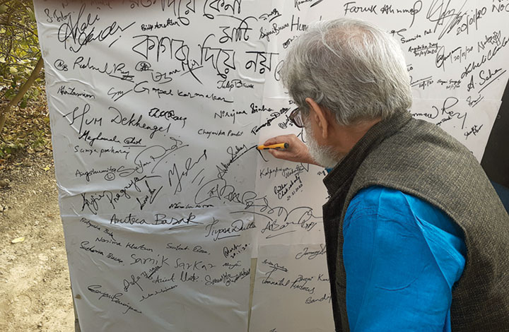 Veteran theatre director Bibhash Chakraborty signs the wall