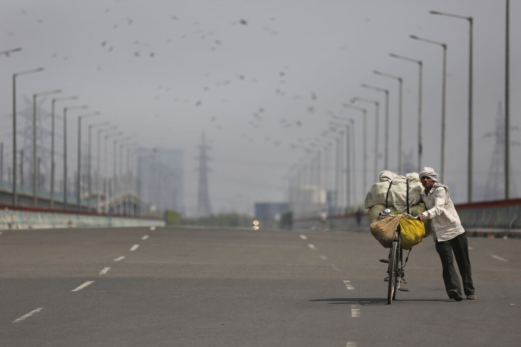 A vegetable vendor pushes his bicycle loaded with vegetables on an empty street during a complete lockdown amid growing concerns of coronavirus in Noida, outskirts of New Delhi, India, on Tuesday.