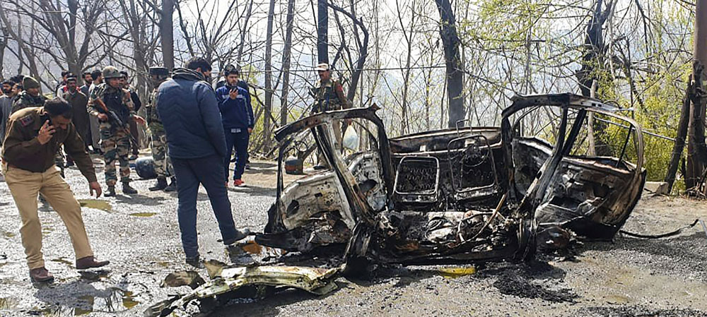 Security personnel inspect the mangled remains of a car which exploded near a CRPF convoy on the Jammu-Srinagar highway at Banihal on Saturday