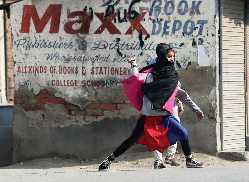 A girl throws stones in Srinagar on Tuesday