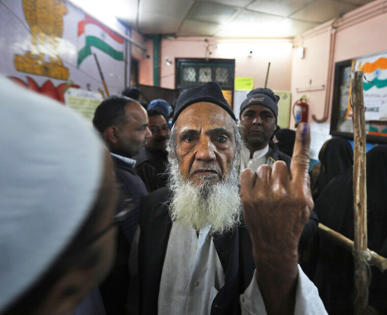 An elderly man shows the indelible ink mark on his finger after casting his vote at a polling station in the old quarters of New Delhi, Saturday, February 8, 2020.