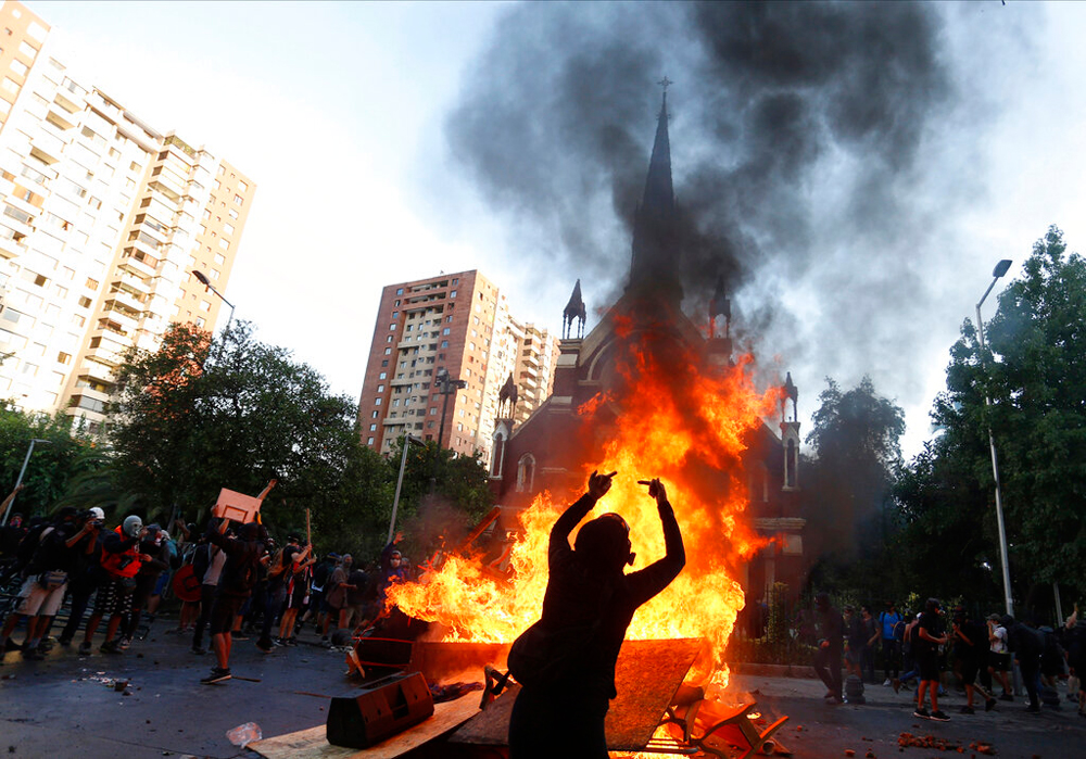 Anti-government demonstrators burn furniture from a Chilean police church during a protest in Santiago on January 3