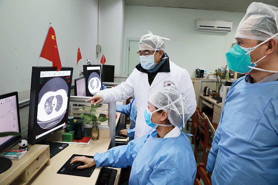 Medical workers inspect the CT scan image of a patient at a hospital in Wuhan, China