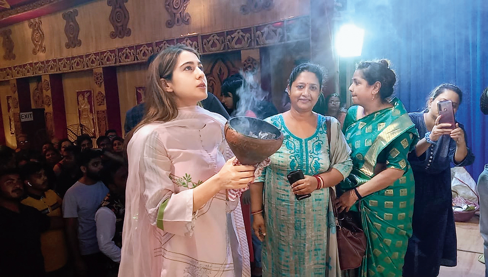 Sara performs arati with the dhunuchi at the DL Block pandal