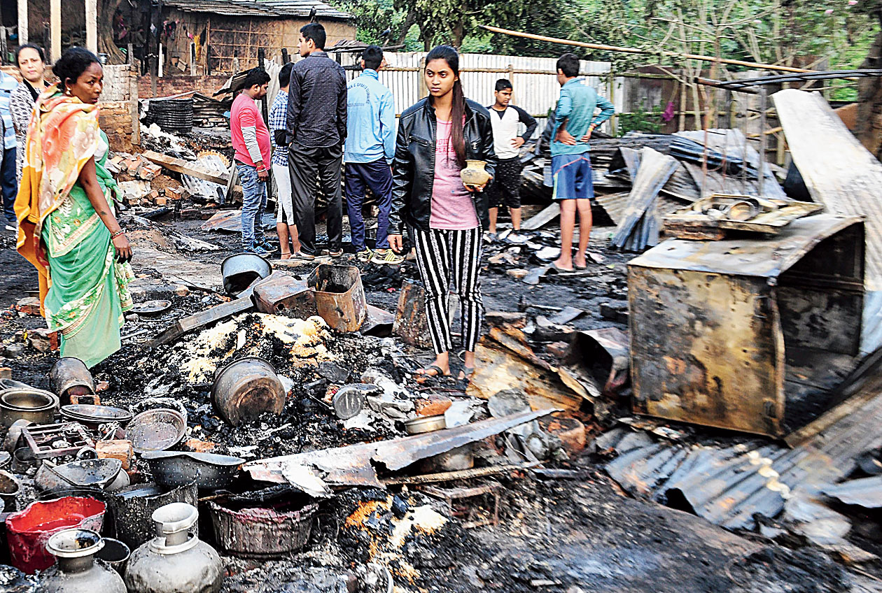 Residents of Harijan Colony at Kahilipara in Guwahati sift thorugh the charred remains of their houses on Wednesday.