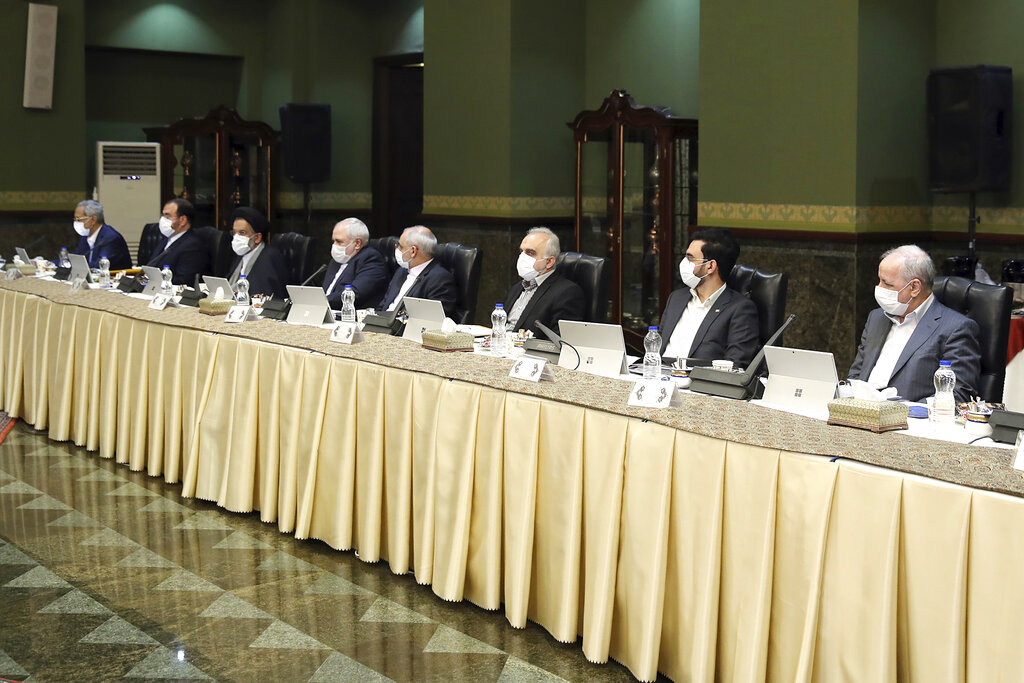 In this photo released by the official website of the Office of the Iranian Presidency, cabinet members wearing face masks attend their meeting in Tehran, Iran, Wednesday, March 18, 2020.