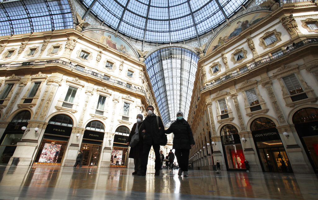 People wear masks as they walks inside Vittorio Emanuele II gallery, in Milan