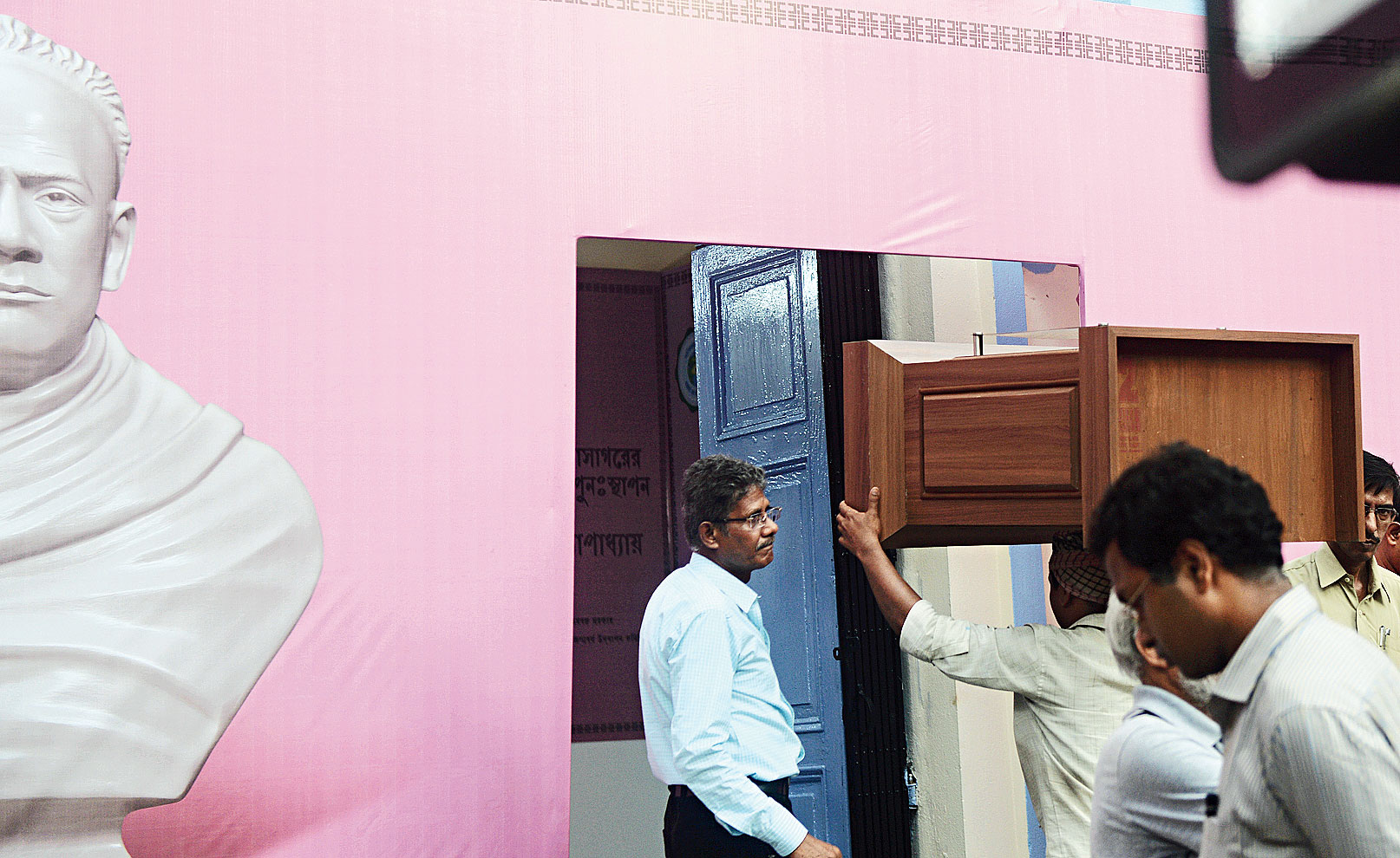 A wooden pedestal, on which Vidyasagar’s bust will be kept, being carried into a room on the ground floor of the college. The bust will be inside a glass enclosure. On May 14, intruders had smashed a similar glass enclosure before vandalising the earlier bust