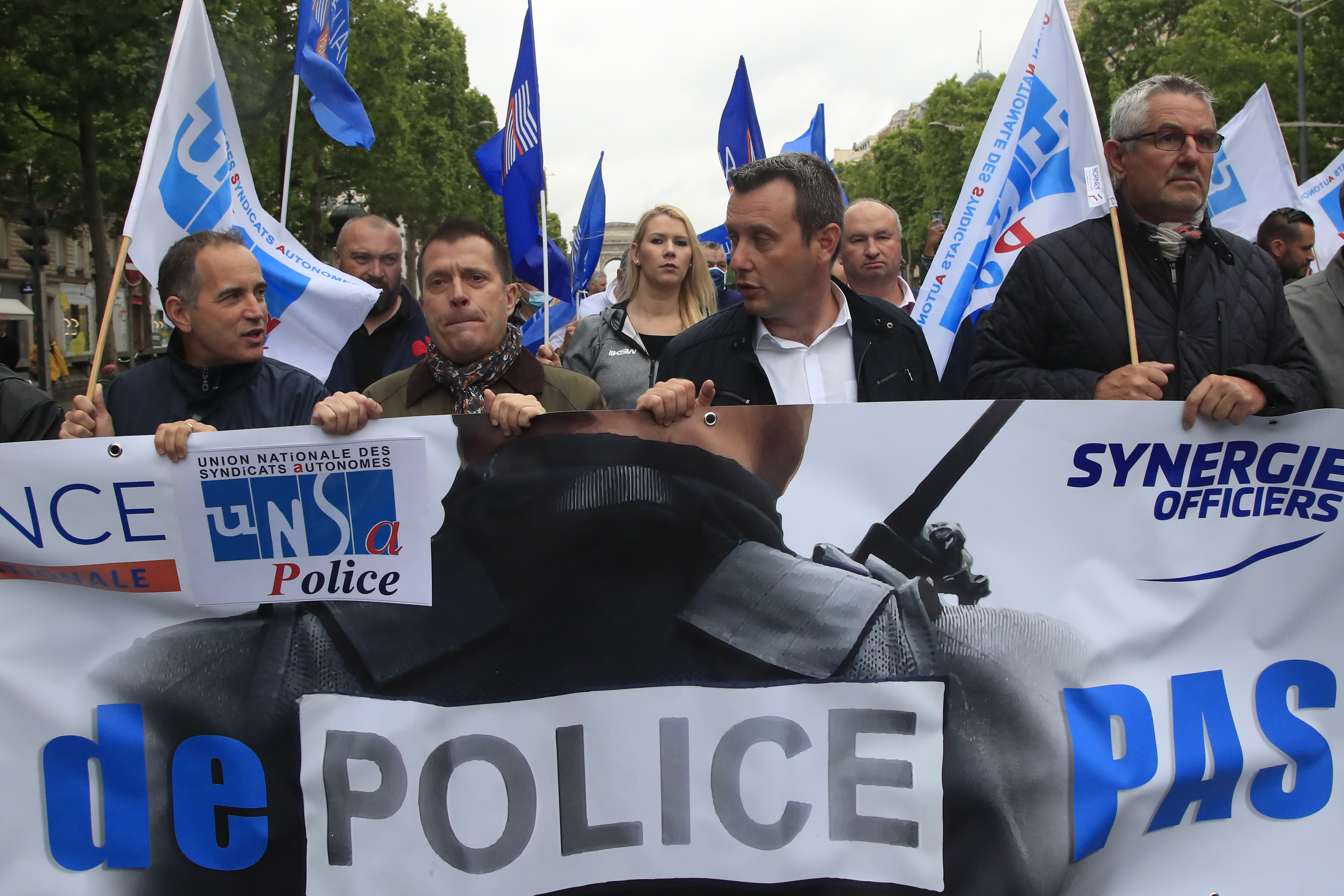 French police unionists demonstrate with a banner reading "No police, no peace" down the Champs-Elysee avenue