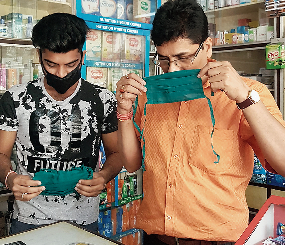 Staff members at BE Block’s Sree Nandan Medical Stores put on masks