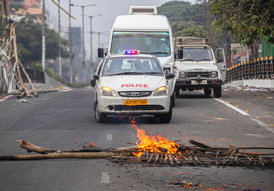 Police escort a team of Japanese security officials as protestors set fire to block traffic in Guwahati, Thursday, December 12, 2019.