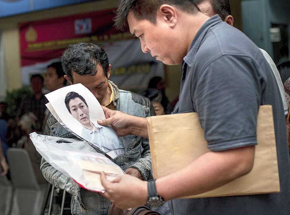 A relative holds a photo of a passenger of the crashed Lion Air flight at the police hospital in Jakarta. 
