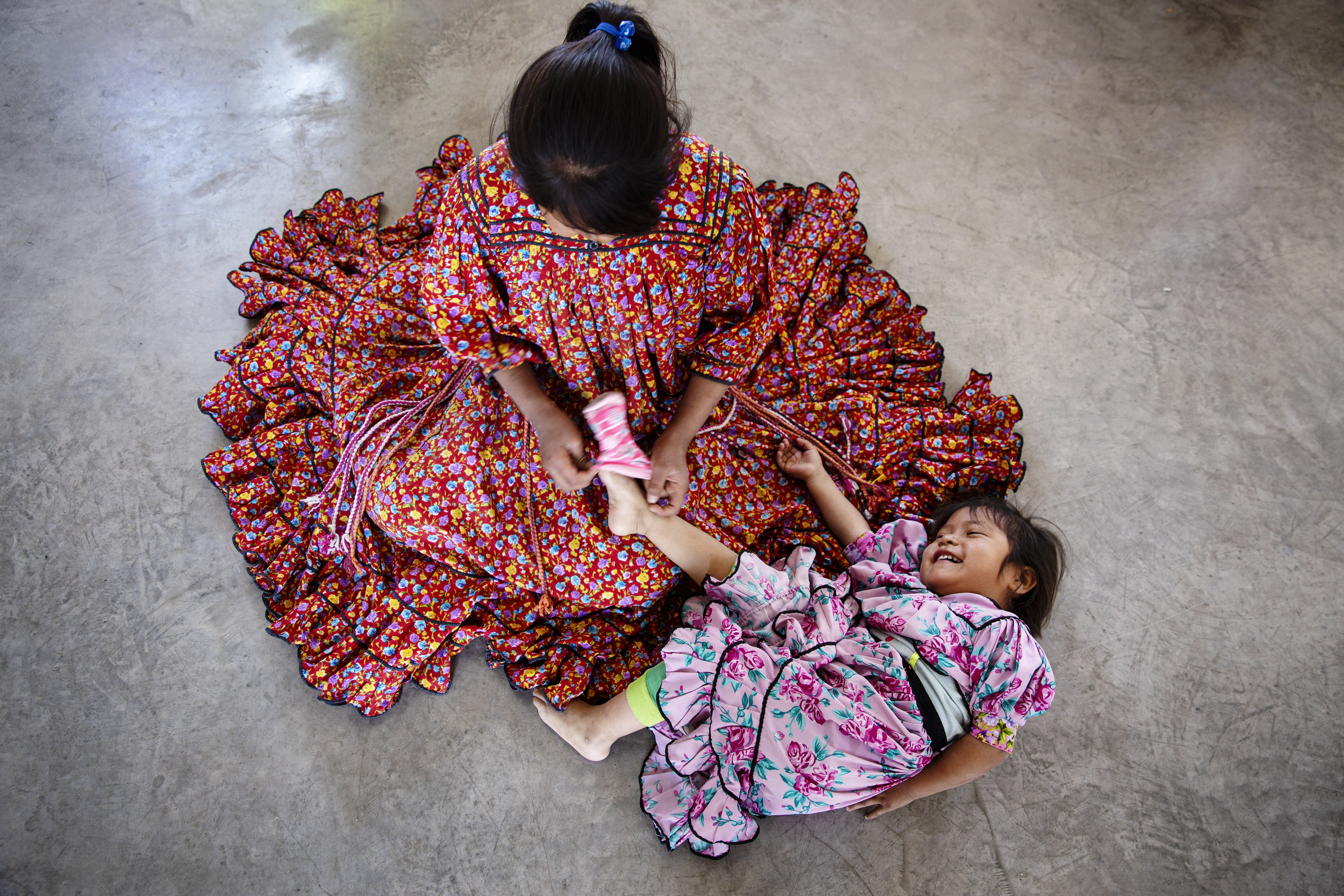 Cela Ramírez, 10, dressing her sister, Rosa Candelaria, 3 at home in a community of indigenous Rarámuri in Chihuahua, Mexico