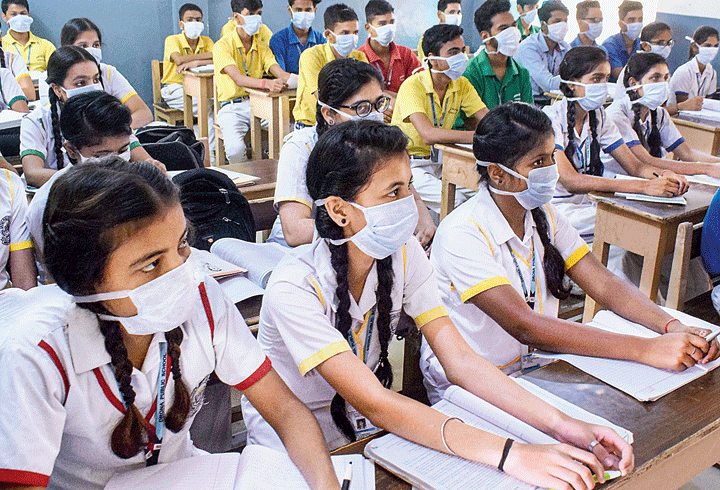 Students wear anti-pollution masks in class in Gurgaon on Saturday.