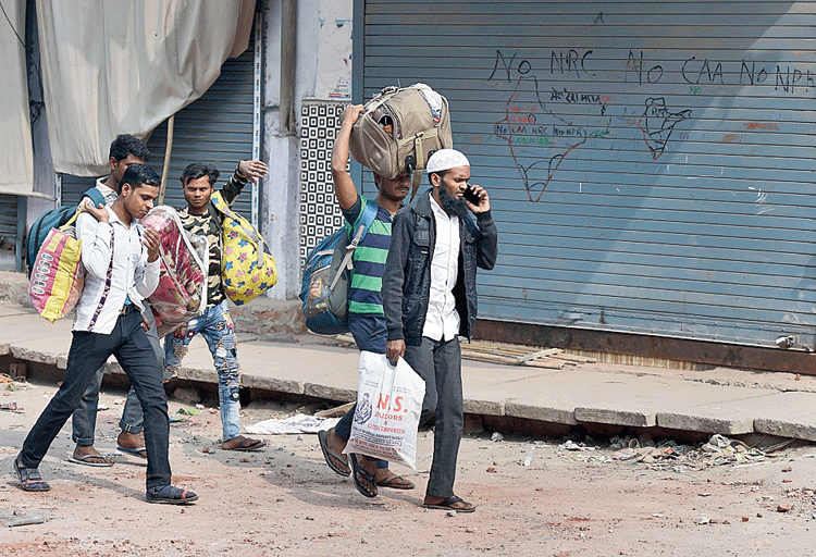 People leave their homes following the violence at Mustafabad, Delhi, on Friday. 